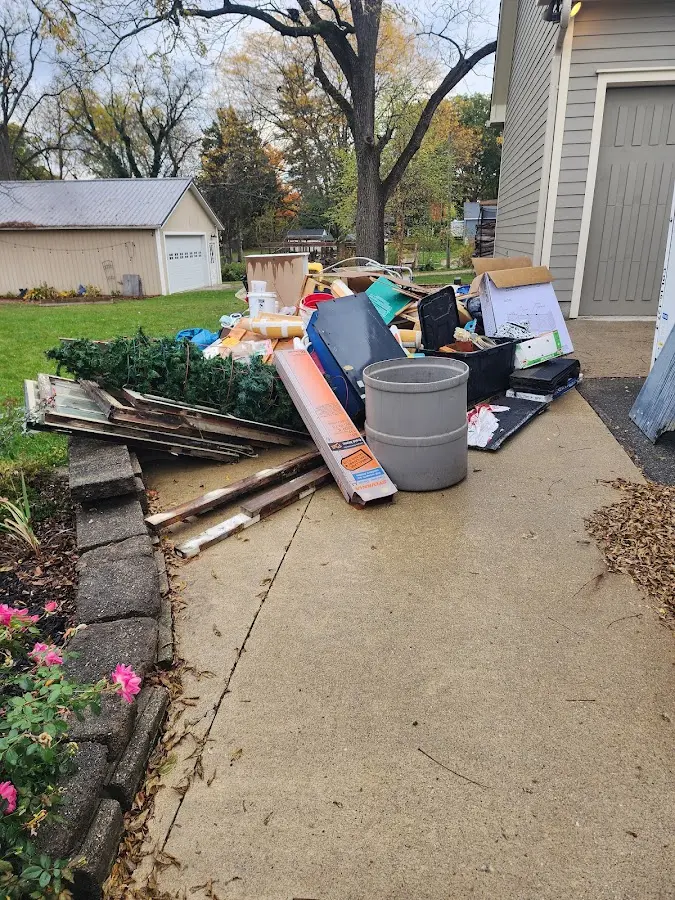 Dumpster being loaded with debris for Estate Cleanout Dumpster Rental in Au Sable